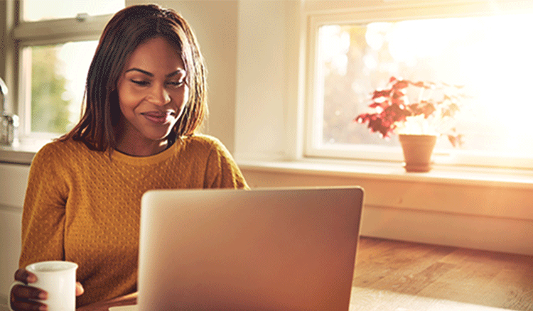 Woman Using Laptop in Dining Room